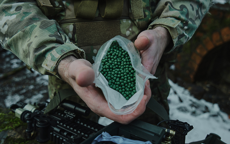 An Airsofter holding a bag of biodegradable BBs.