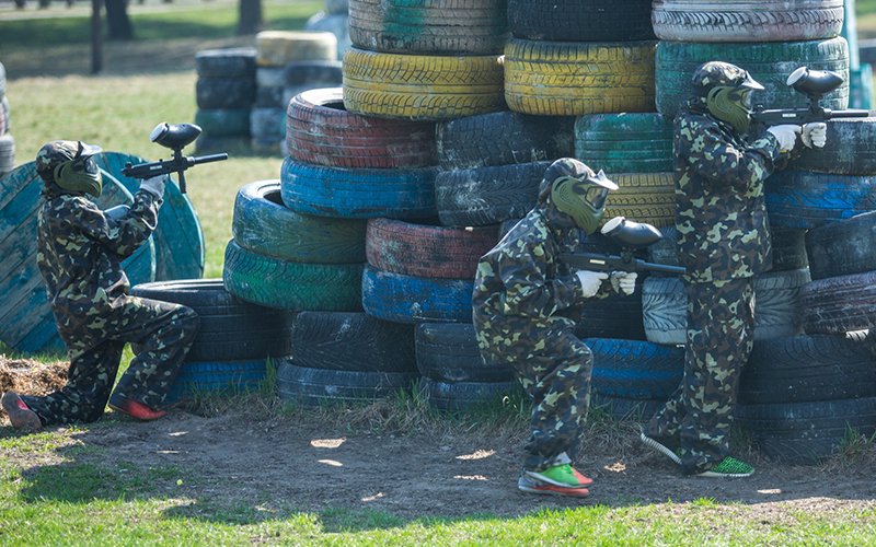 Group of Paintballers taking cover behind tires.