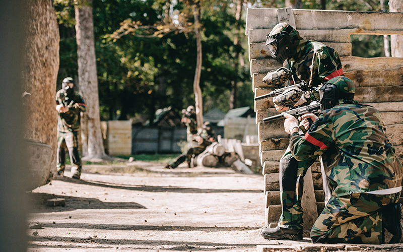 A paintball duo hiding behind cover.