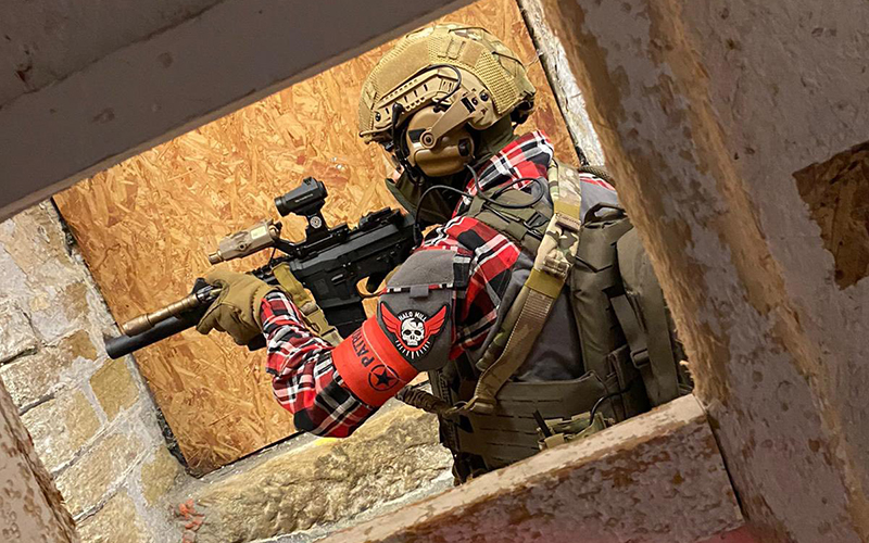 An Airsofter moving down a narrow corridor.