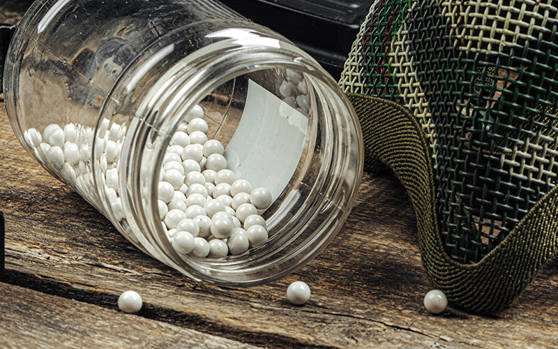 Spilt bottle of BBs with a face mask next to it